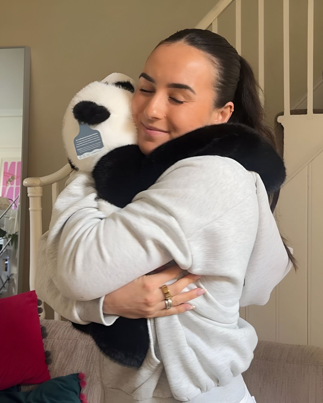 Someone hugging a weighted Pookie the Panda at home
