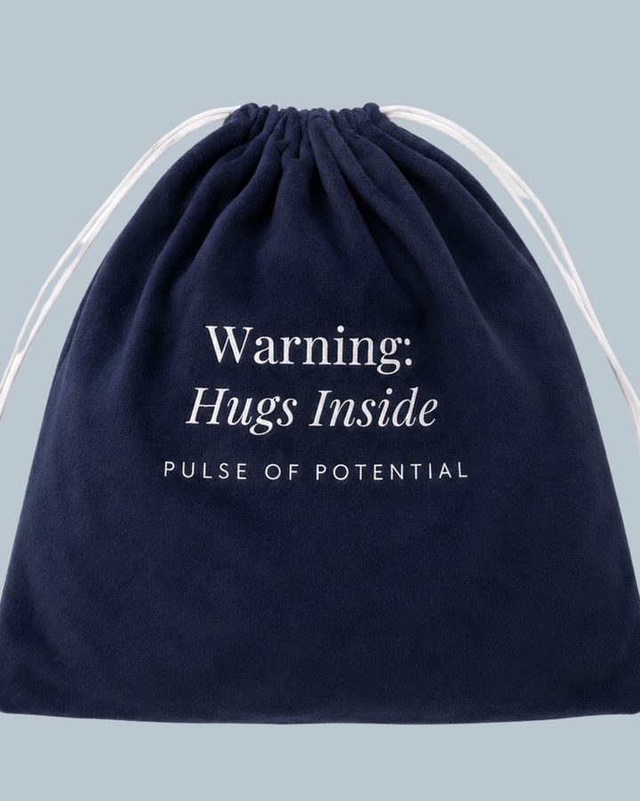 A navy drawstring gift bag printed with Warning: Hugs Inside