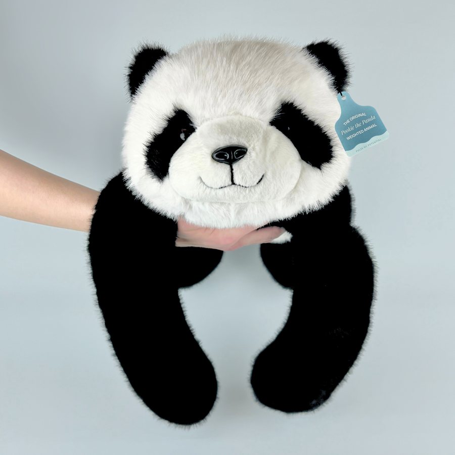 A weighted panda held up under its head, its long black arms hanging down